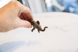 A small vintage African bronze elephant held in hand, showing its textured finish and scale.