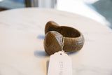 Angled profile of a vintage African copper bracelet highlighting its handcrafted geometric details.