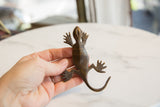 Vintage African dark bronze gecko sculpture with textured head and front legs.