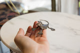 Vintage African dark bronze collectible gecko held in hand, unique handmade texture.