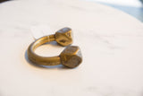 Side profile of an antique Tuareg bronze cuff highlighting its sculptural form and gold patina.