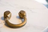 The thick, curved form and faceted terminals of an antique Tuareg cuff bracelet.