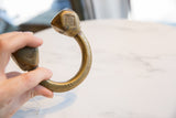 Antique African Tuareg cuff bracelet held, showing its heavy bronze build and etched geometric details.