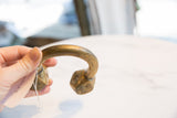 Antique Tuareg bronze cuff held in hand, displaying its sculptural form and aged patina.