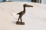 Profile view of the vintage dark bronze stork highlighting its textured, handmade form.
