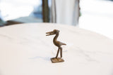 Vintage dark bronze stork figure shown in profile on its square base.