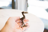 Vintage dark bronze stork figurine held in hand to show its collectible scale.