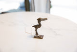 Profile of the vintage handmade African bronze stork with its head turned.