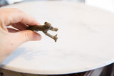 Underside view of the vintage bronze monkey highlighting the handcrafted form of the legs.