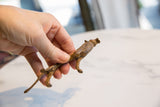 Vintage African bronze alloy lion figurine, held in hand, showcasing its aged texture.