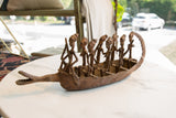 Patinated African bronze crocodile boat, showing detailed passengers and texture.