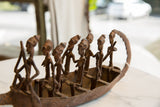 Close-up of patinated antique bronze figures revealing handmade detail and texture.