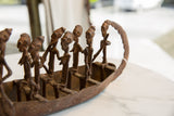 Patinaed bronze boat stern, highlighting lost wax cast figures and detailed craftsmanship.