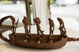 Close-up of the antique bronze crocodile boat's tail, showcasing its aged patina.