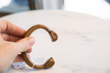 Detailed end of antique African copper bronze snake cuff with time-softened patina.
