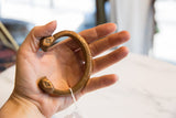 Antique African copper and bronze snake cuff bracelet, displaying etched lines and diamond motif.