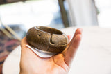 Antique bronze African bracelet held in hand, highlighting its thick form and scale.