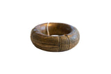 A thick antique African bronze bracelet with an aged patina and intricate geometric carvings.