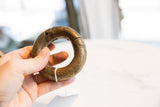 Antique African bronze bracelet with a dark, aged patina held in hand for scale.