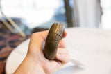 Antique African bronze bracelet held to show its substantial size and carved geometric pattern.