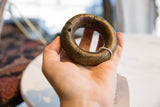 Side view of a collectible antique African bronze bracelet with a deep, time-softened patina.