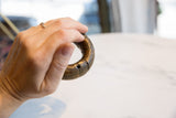 Antique African bronze bracelet held to display its substantial size and carved details.