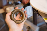 Antique African bronze bracelet held in hand, showing its substantial size and warm patina.