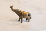 Vintage African bronze alloy elephant side view, showing raised trunk and back slit.