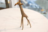 Vintage African bronze alloy giraffe, showing textured body and short tail.