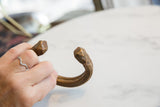 Antique African snake cuff bracelet held in hand to demonstrate its scale and patina.
