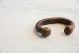 Hand-worked ribbed texture and dark, aged patina on an antique copper snake cuff.