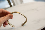 The smooth curve and aged surface of the antique bronze alloy cuff bracelet.