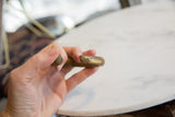 A detailed view of the hand-forged, textured ends of the antique bronze cuff.