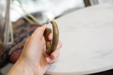 Side profile of the antique bronze snake cuff showing its thick, rounded form and aged patina.