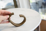Antique bronze cuff with gold patina held to show its scale and form.