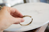 Vintage African bronze cuff bracelet held to show its simple, rustic form and scale.