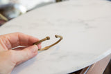 Vintage African bronze cuff held to show its handmade form and scale.