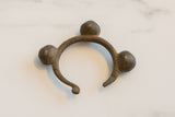 Collectible African bronze currency cuff with a dark patina and three bell-shaped accents.