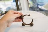 Vintage African bronze bell cuff held to show its scale and sculptural form.