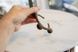 Vintage African bronze bell cuff held in hand, showing its scale and texture.