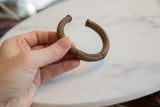 Antique African copper cuff bracelet held in hand, showing scale and geometric details.