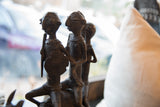 Detailed view of handmade African bronze warrior figures with textured patina and spiral shield.