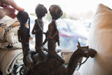 Vintage handmade bronze African warriors' legs on camel's textured body.