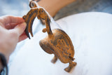 African bronze bird pulley head detail, featuring rich rustic texture and time-softened patina.
