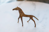 Vintage African copper alloy horse in profile, highlighting its slender form and aged patina.