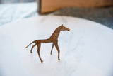 Elegant profile of a vintage African copper horse with a warm, aged patina.