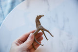 Vintage African copper alloy horse held to show its handmade texture and scale.