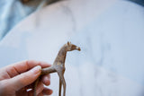 A hand holding the vintage African copper horse, showing its scale and handmade texture.