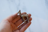 Vintage bronze llama held in hand, showing its small scale and handmade texture.