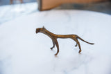 The slender profile and aged texture of a handmade bronze cheetah sculpture.